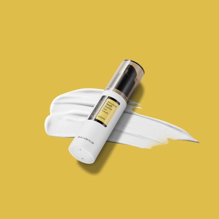 Crème contour des yeux Advanced Snail Peptide Eye Cream sur fond jaune avec application de crème blanche et flacon élégant Mi Young Cosmetics.
