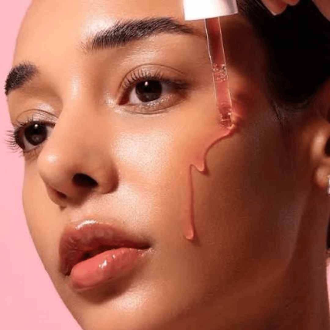 Femme appliquant quelques gouttes du sérum Anua sur son visage pour un teint éclatant.