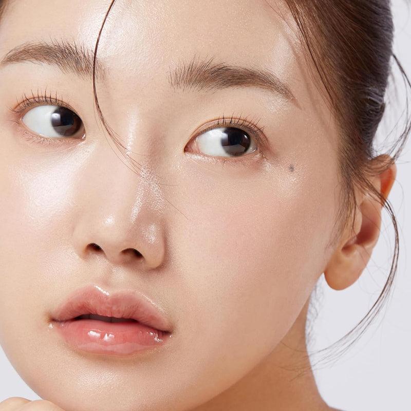 Jolie portrait de jeune femme asiatique au teint clair et peau lumineuse, première planité, maquillage minimal, peau nette et hydratée. texte: comment commencer la skincare.