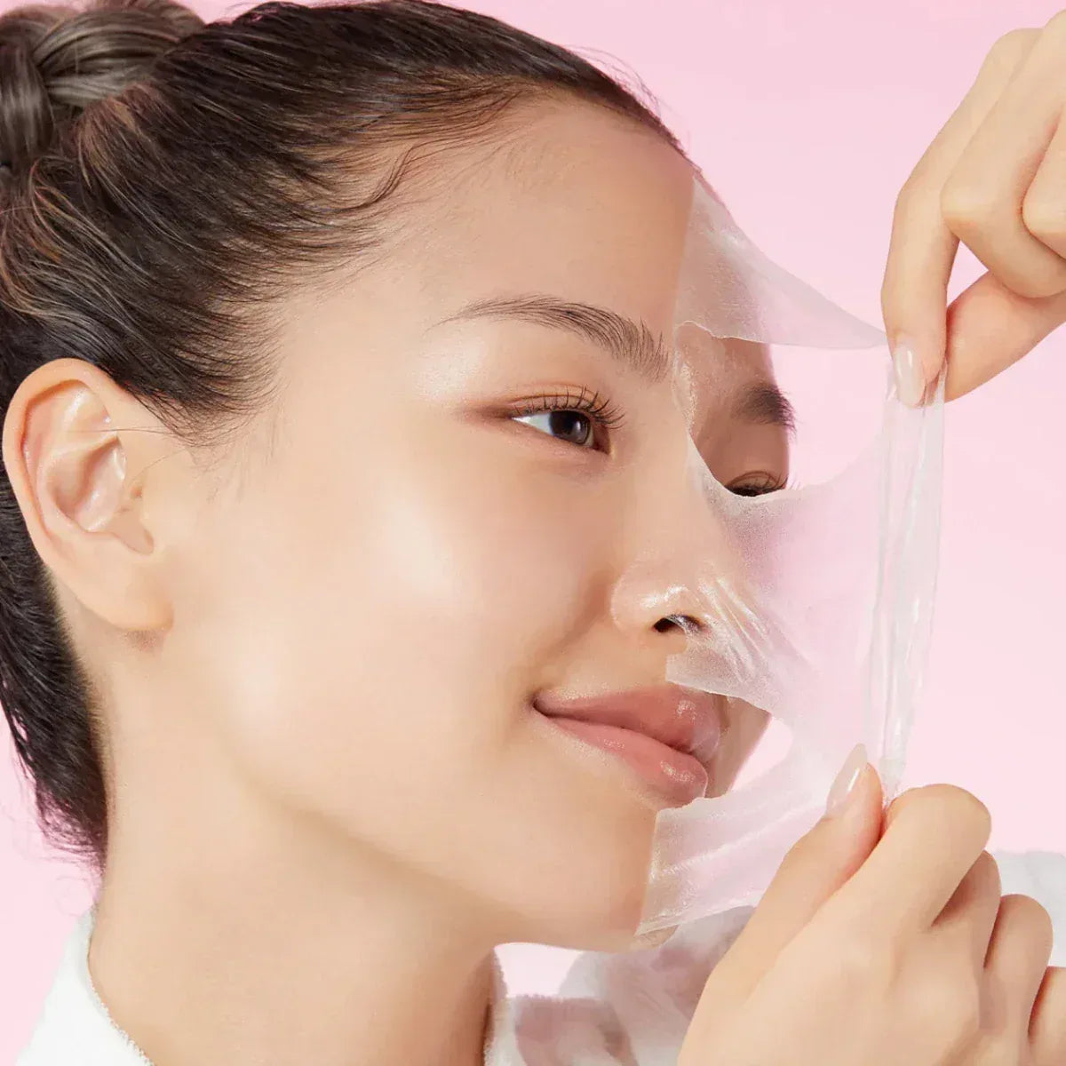 Application du masque en film transparent Medicube au collagène sur le visage pour un effet peeling de nuit